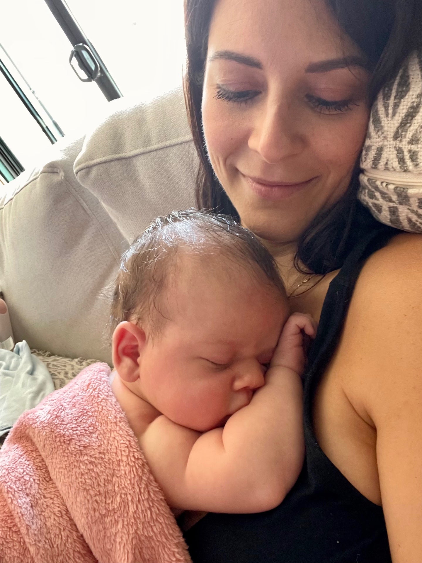 Emily holding her sleeping newborn son close